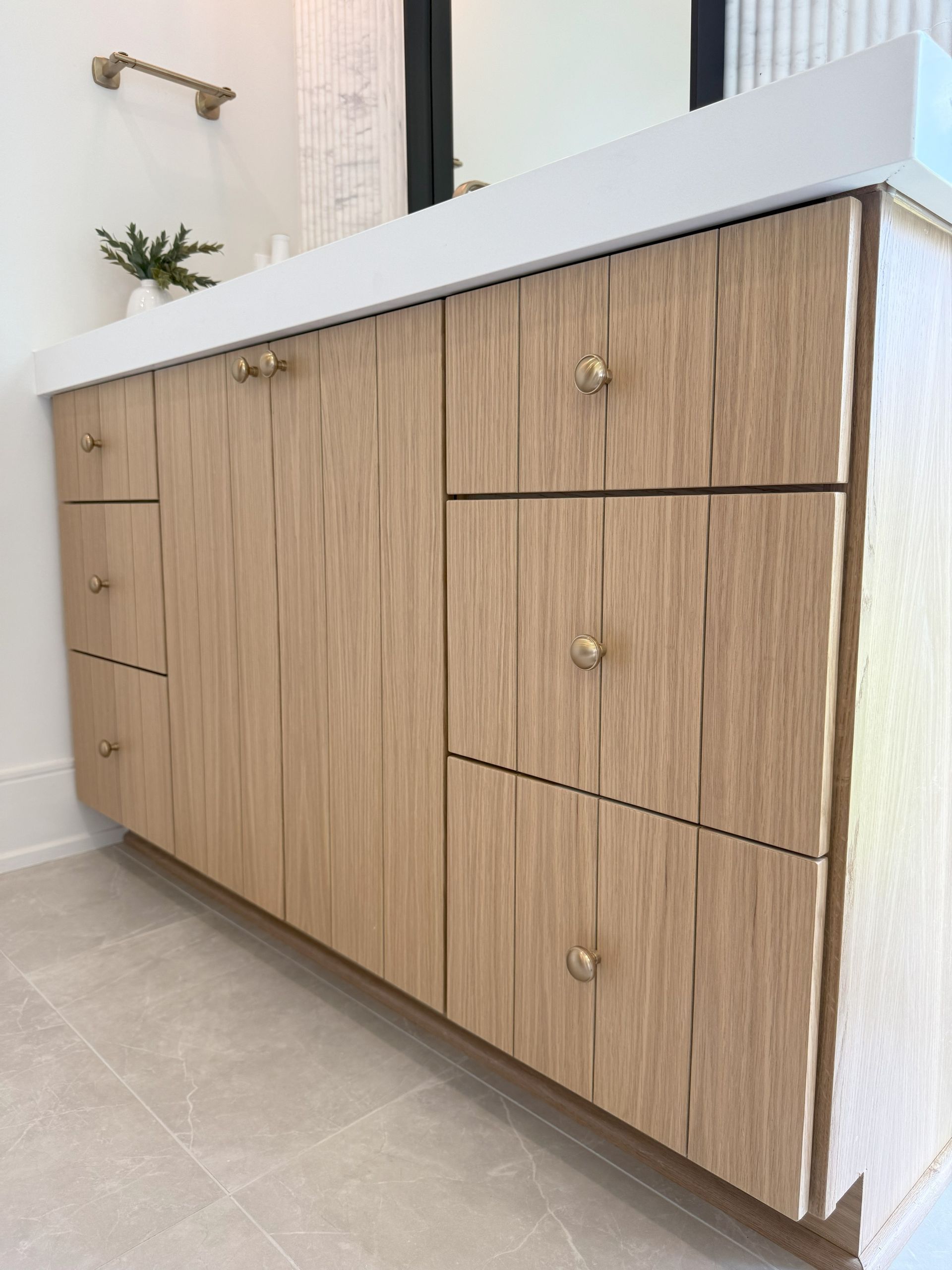 A bathroom vanity with wooden cabinets and drawers.