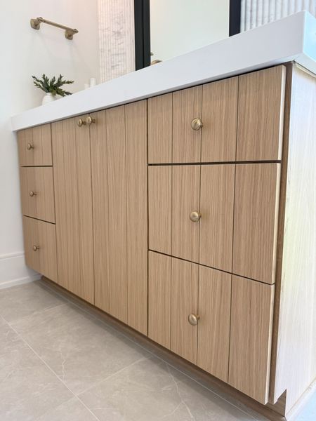A bathroom vanity with wooden cabinets and drawers.