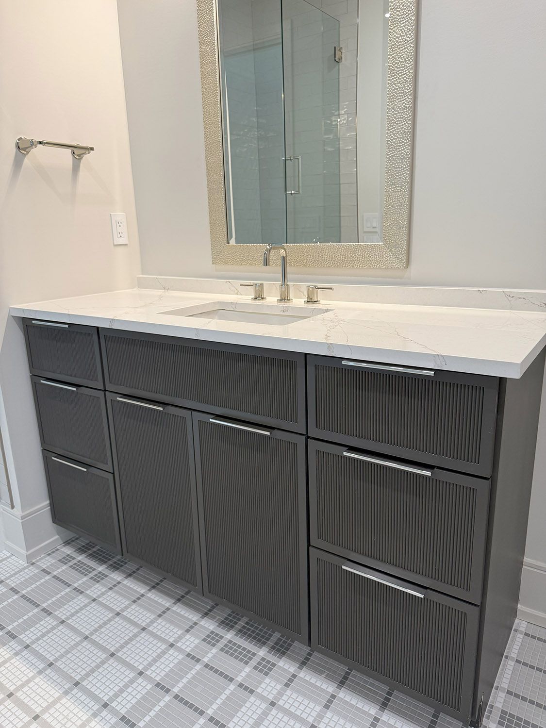 A bathroom with a sink, mirror, and drawers.