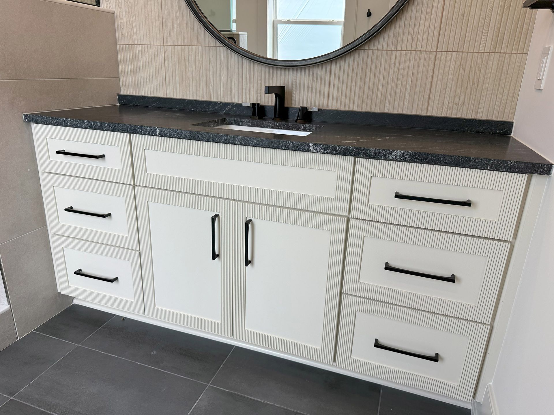 A bathroom vanity with a sink and a mirror.