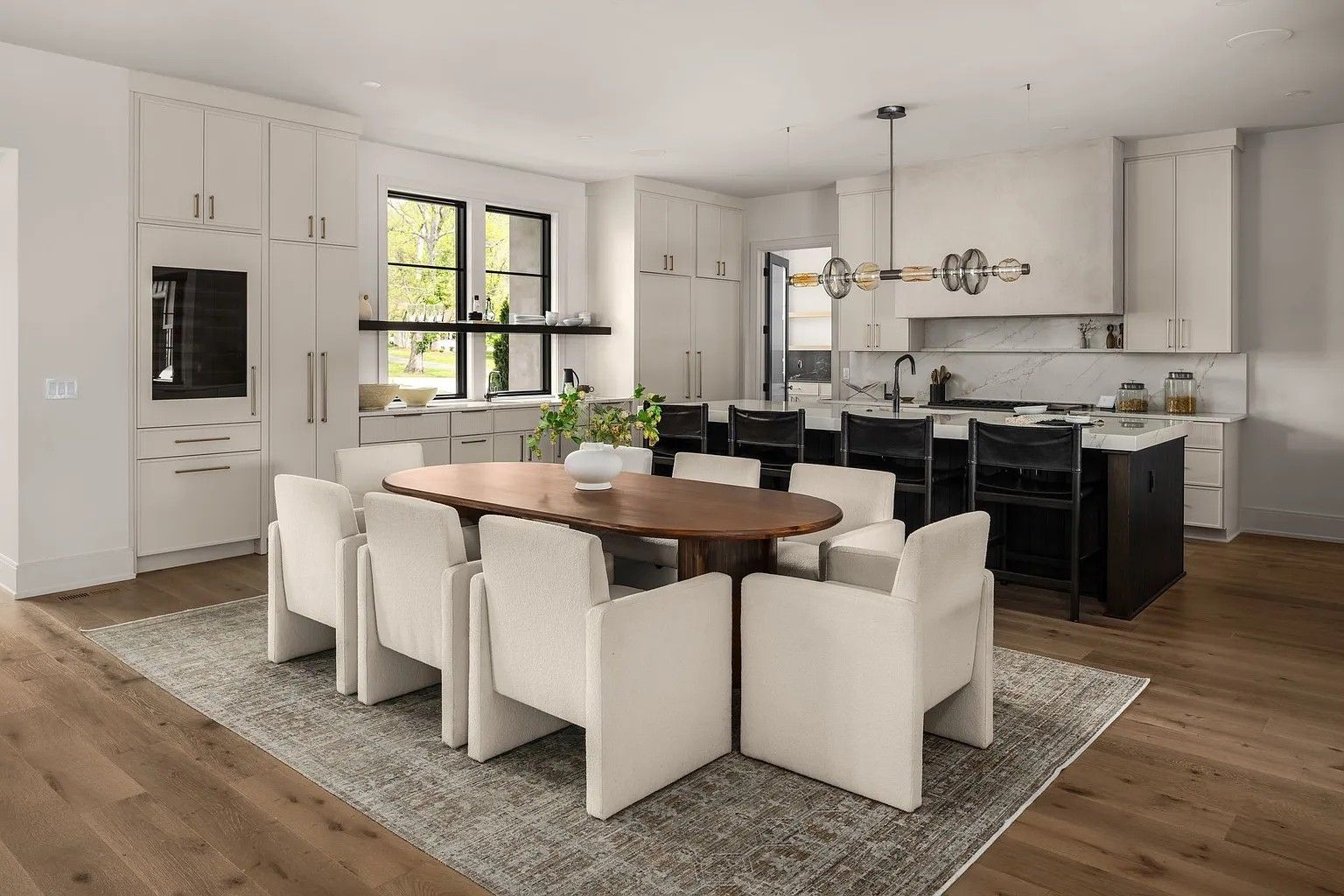 A dining room with a table and chairs in a kitchen.