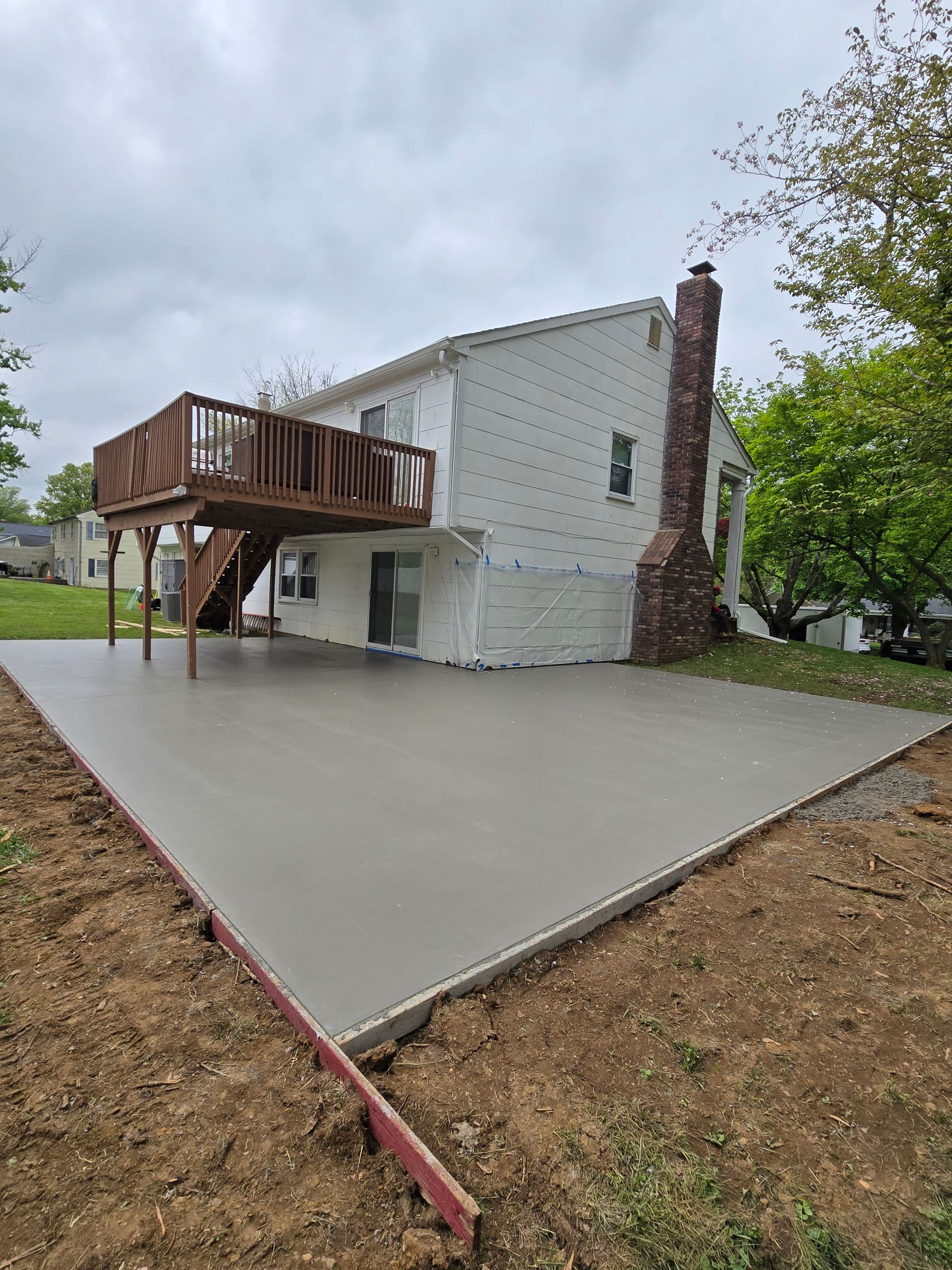 A concrete slab is being constructed in front of a house