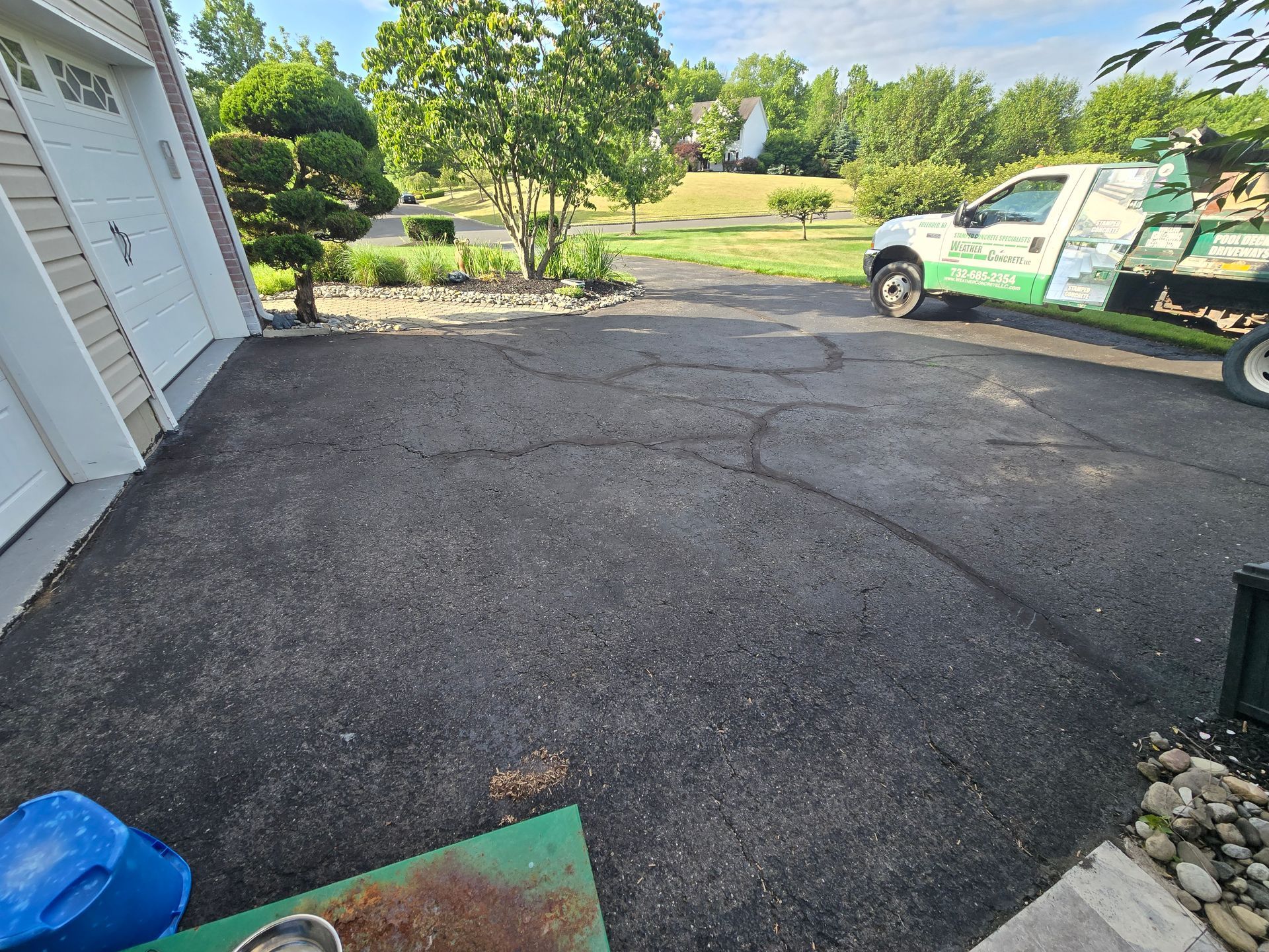 A truck is parked in a driveway next to a garage