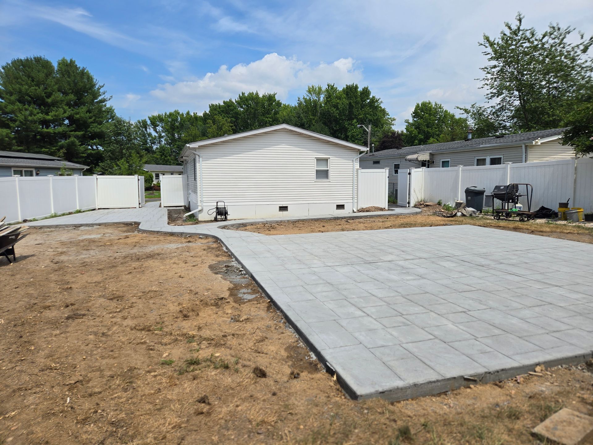 A concrete driveway is being built in the backyard of a house