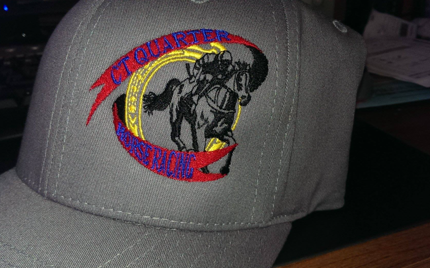 A baseball cap with a horse and rider embroidered on it