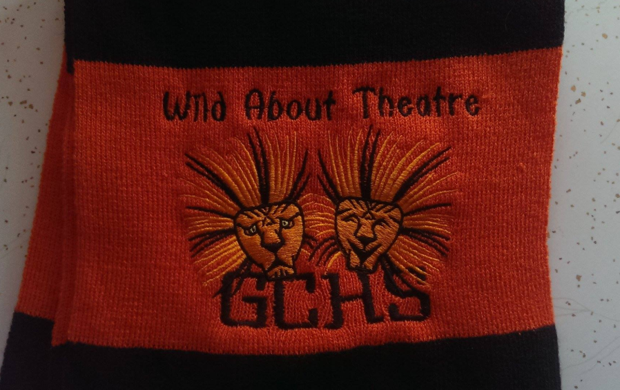 A scarf that says wind about theatre on it