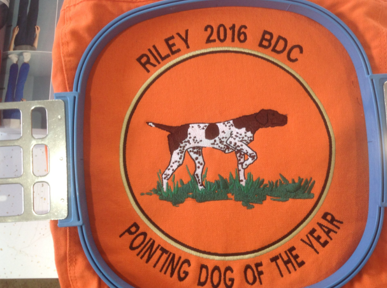 A patch that says pointing dog of the year on it