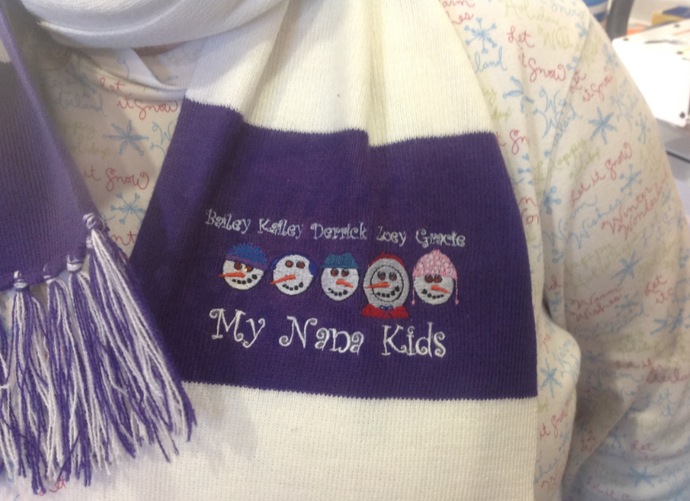 A person wearing a scarf that says my nine kids