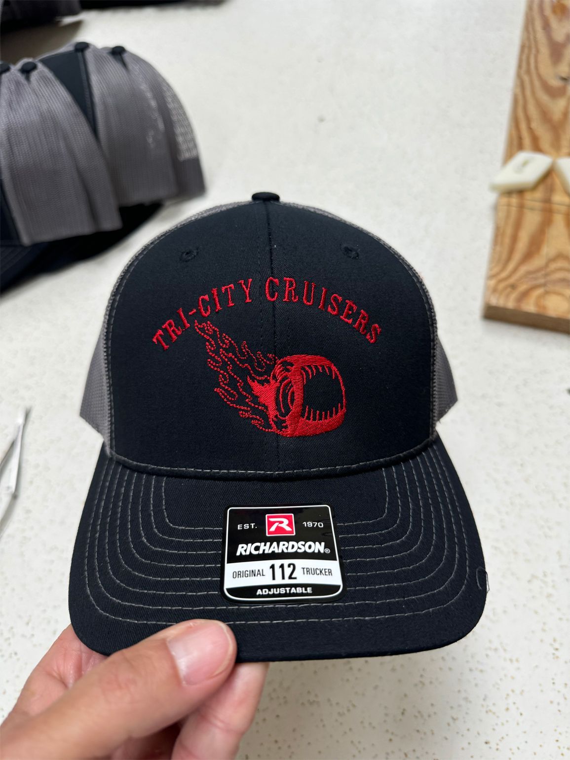 A person is holding a hat that says tri-city cruisers