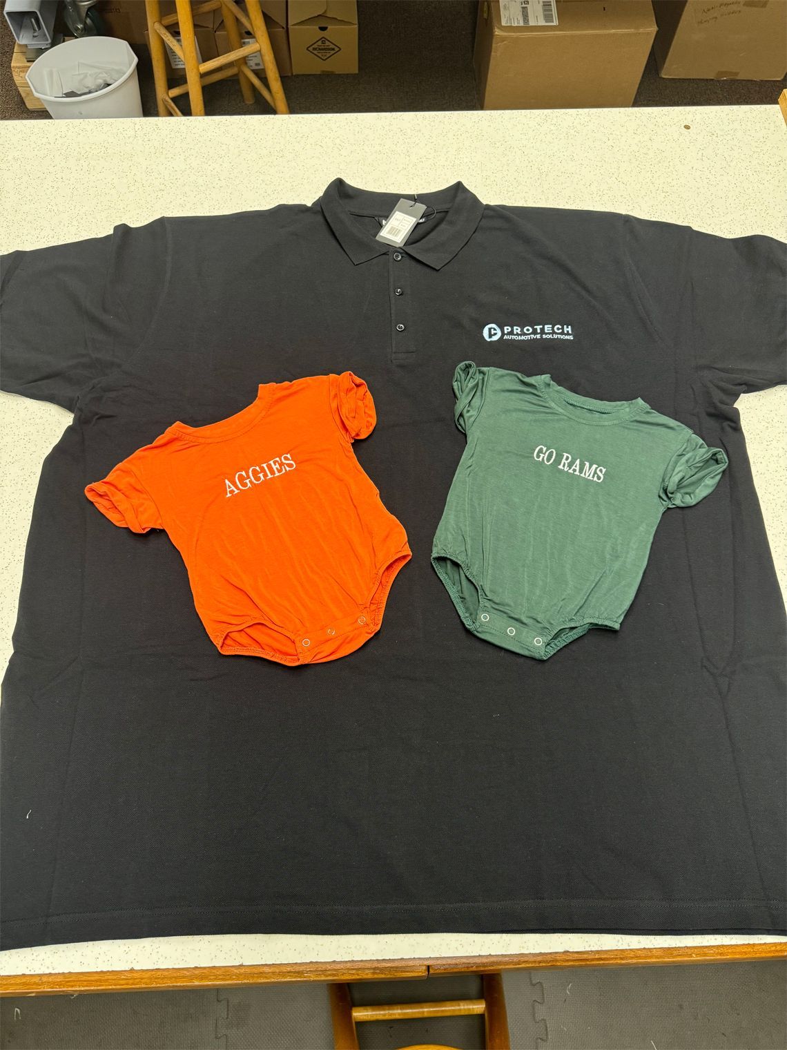A polo shirt and two baby shirts are on a table