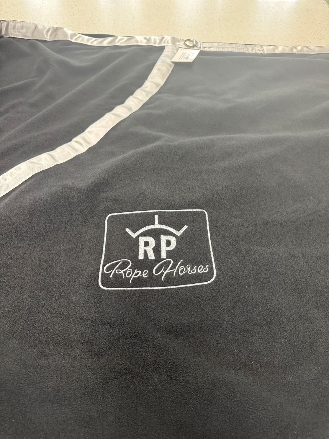A black blanket with the word rp embroidered on it