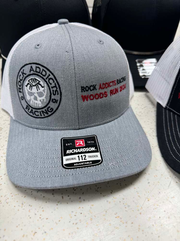 Gray and white trucker hat with Rock Addicts Racing logo.