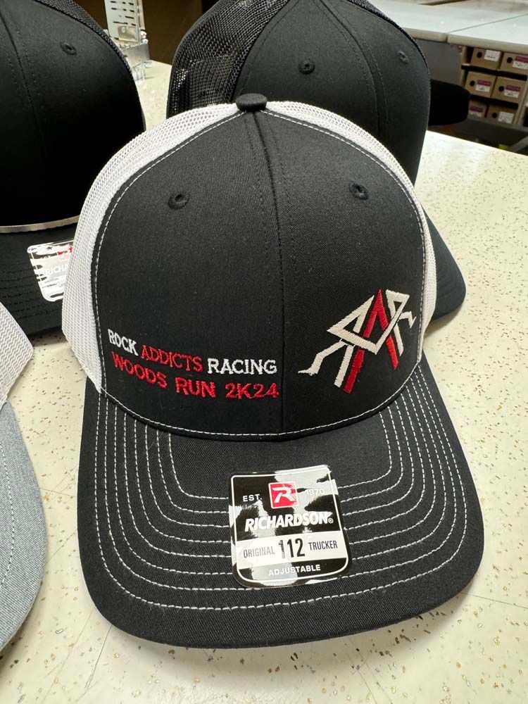 Black and white trucker hat with Brick Addicts Racing Woods Run 2K24 embroidered on the front.