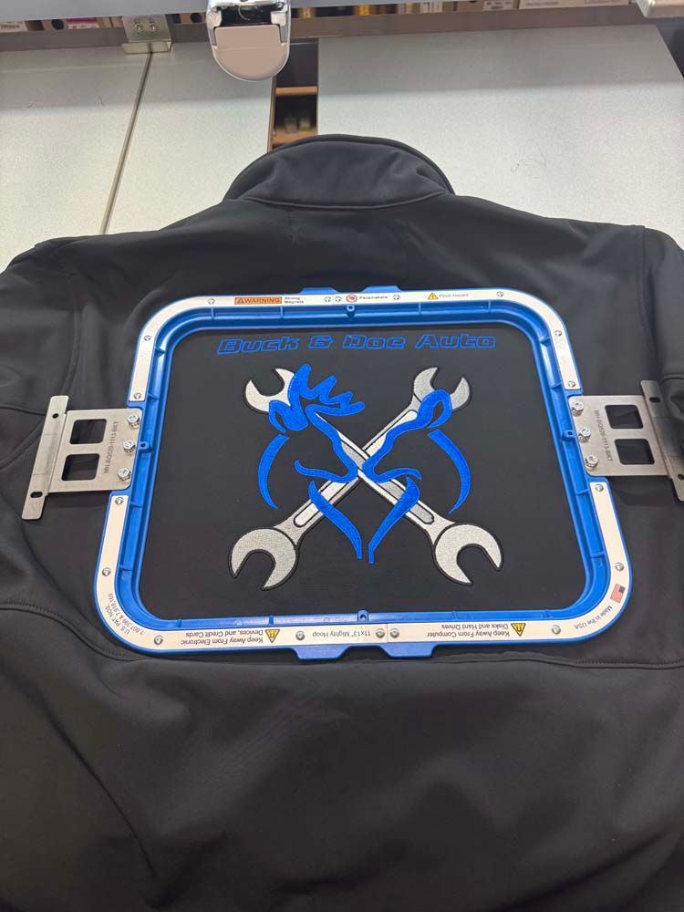 Black jacket with blue and white embroidered crossed wrenches.