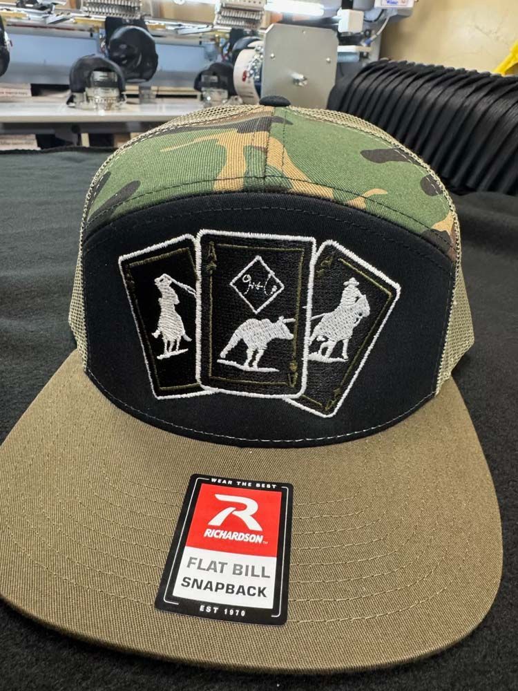 Camo-topped snapback hat with playing card design.