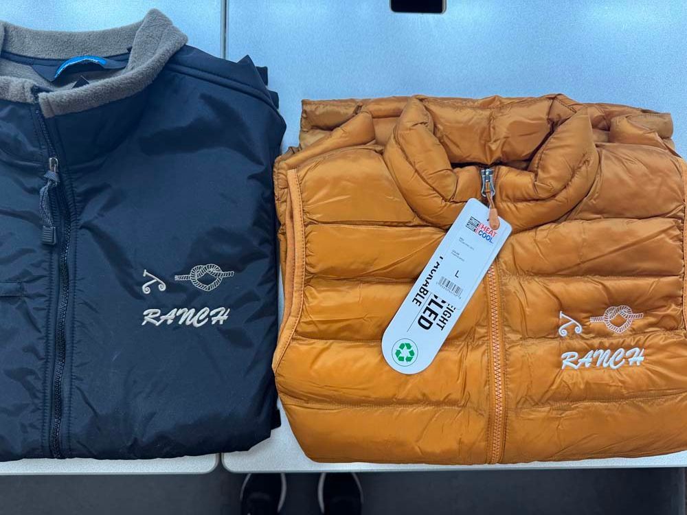 Puffer vests, navy and gold, displayed on a shelf.