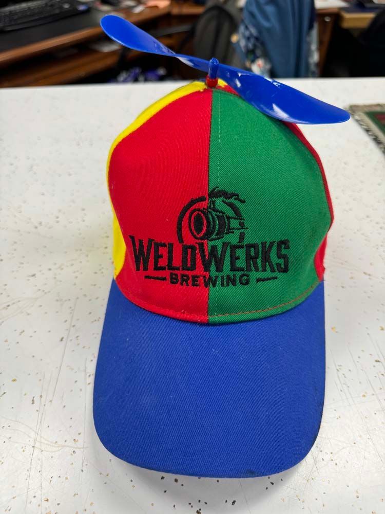 Colorful cap with propeller, WeldWerks Brewing logo.