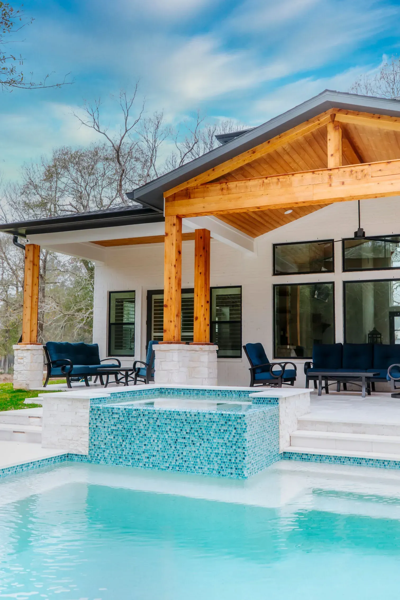 Modern white house with a covered patio and turquoise pool in front