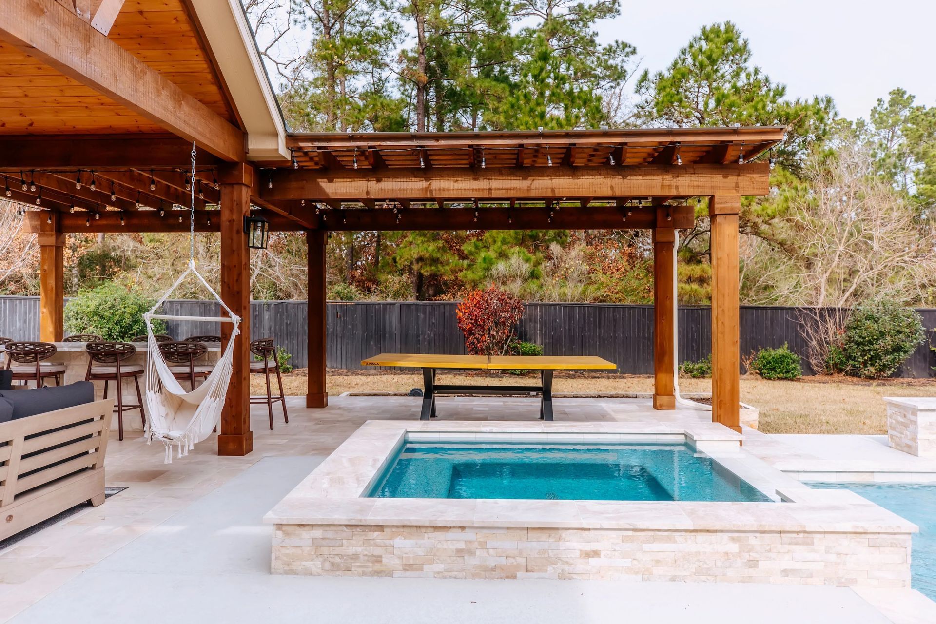 Backyard patio with pergola, hammock, and small turquoise plunge pool