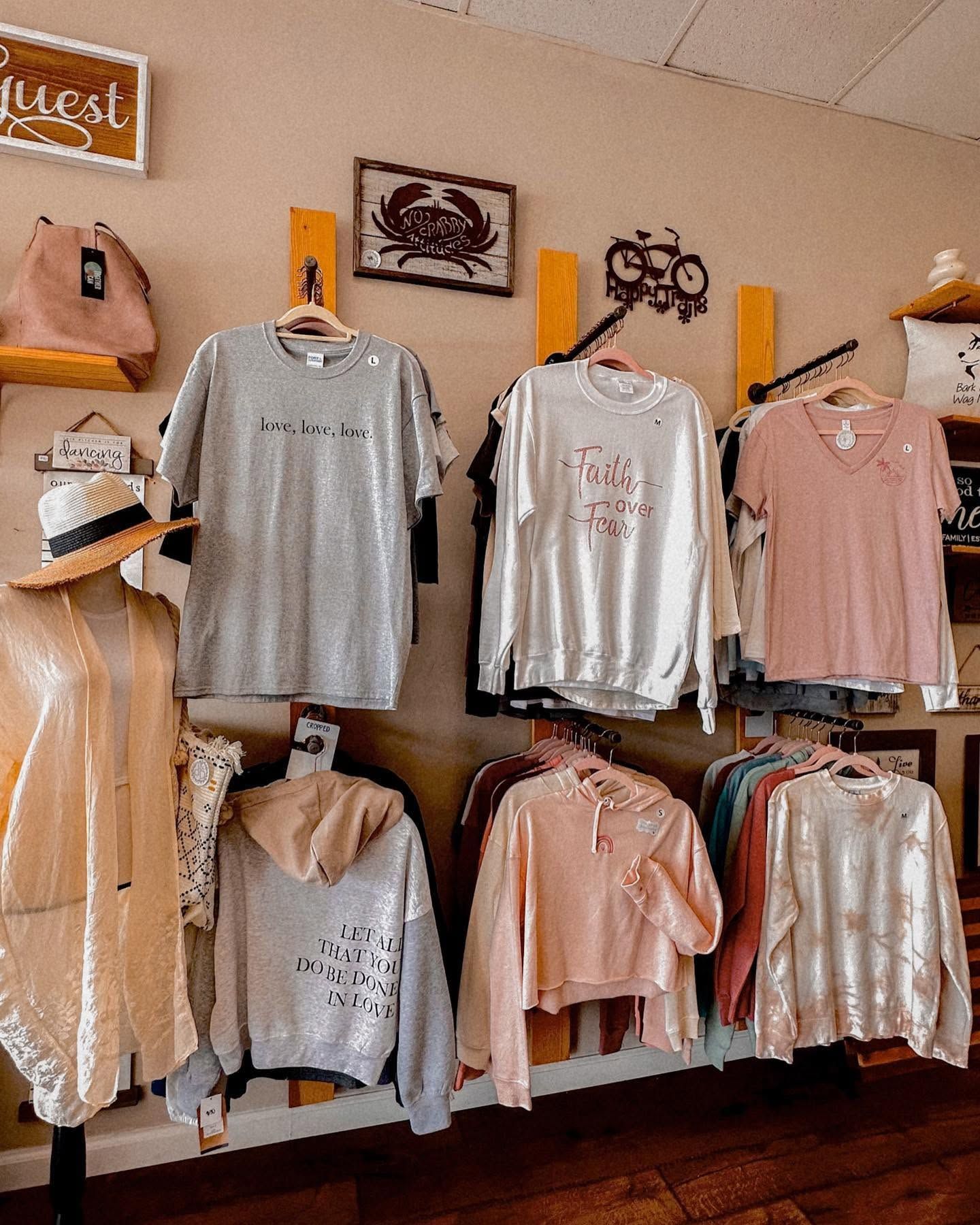 Wall display of pastel sweatshirts and tops hanging in a boutique shop