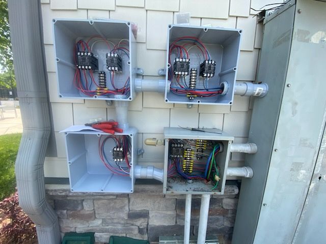 A bunch of electrical boxes are hanging on a wall.
