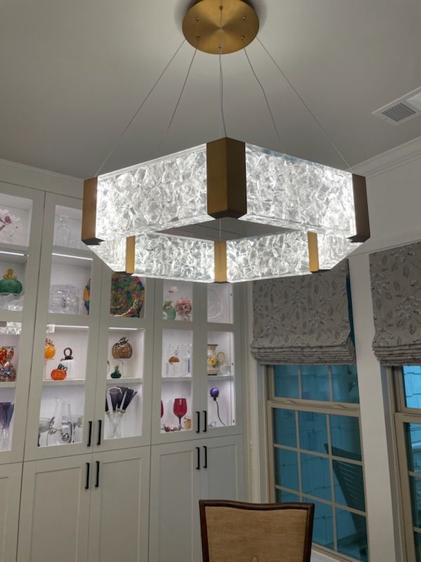 A dining room with a chandelier hanging from the ceiling