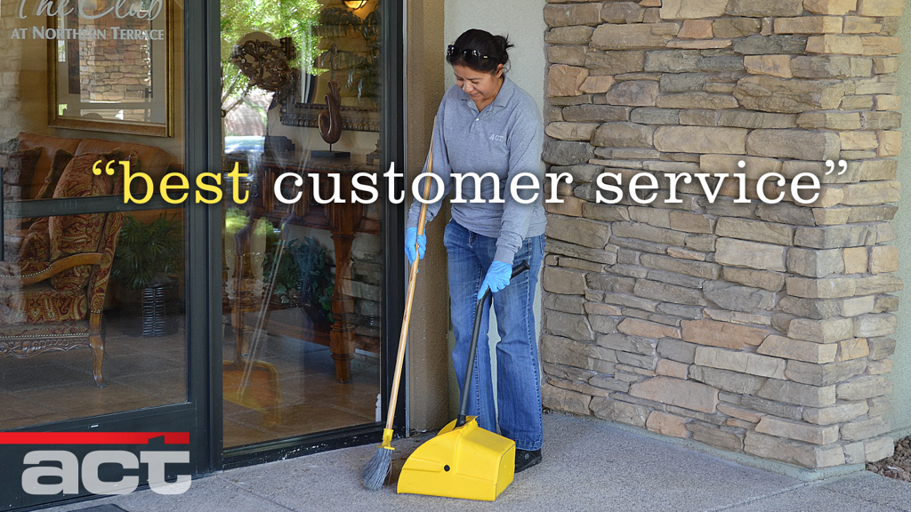 Woman sweeping outside building with stone facade