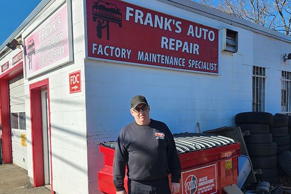 A man is standing in front of Frank's Auto Repair