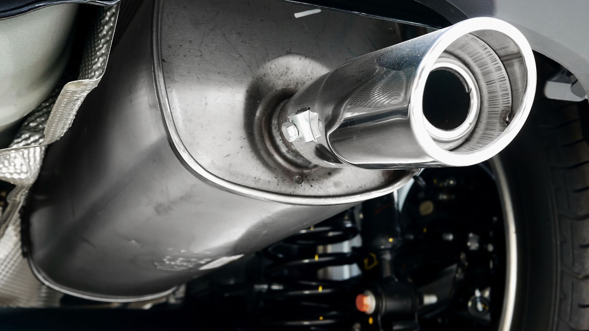 A close up of a car exhaust pipe on the back of a car