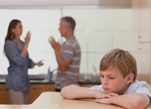 Sad little boy hearing his parents having an argument
