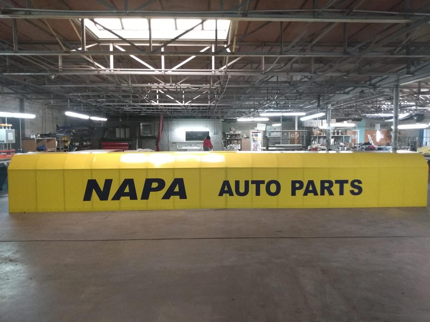 Yellow NAPA AUTO PARTS sign in a warehouse setting.