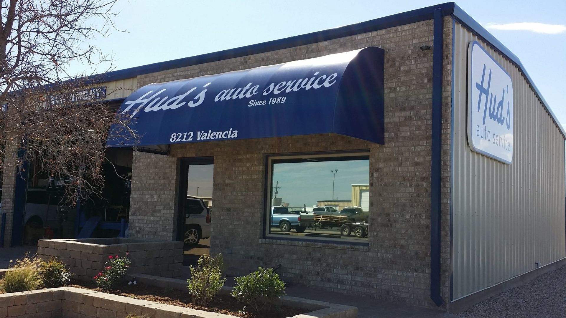 Hud's Auto Service building with blue awning and sign; exterior shot.