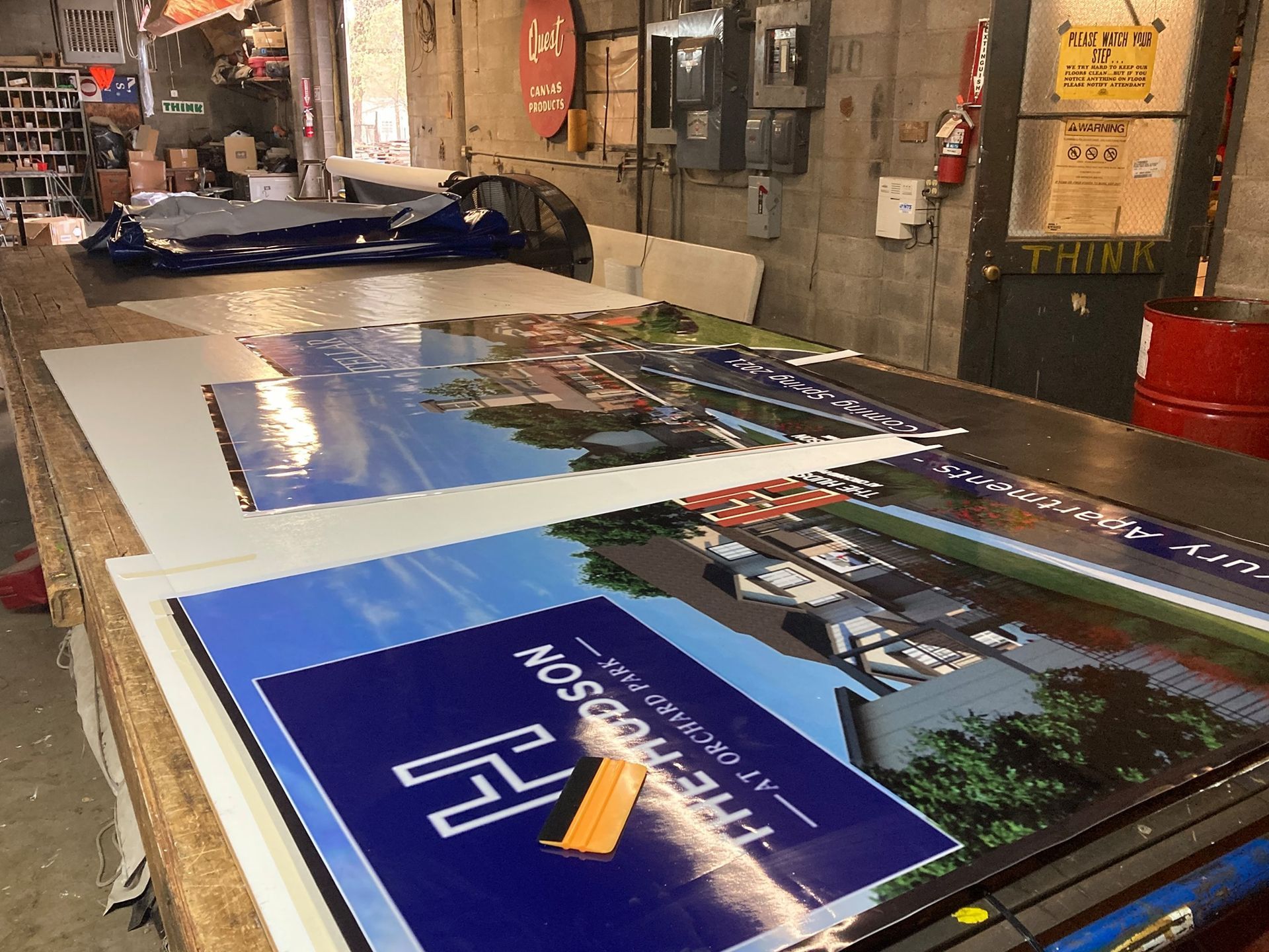 Signage being prepped on a large table. The sign reads 