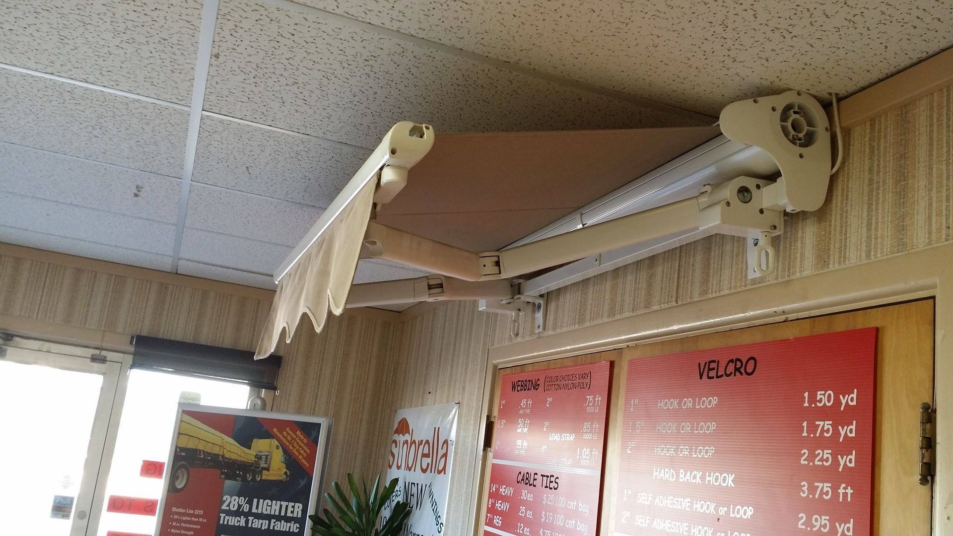 Beige retractable awning mounted above a doorway, extending from the wall.