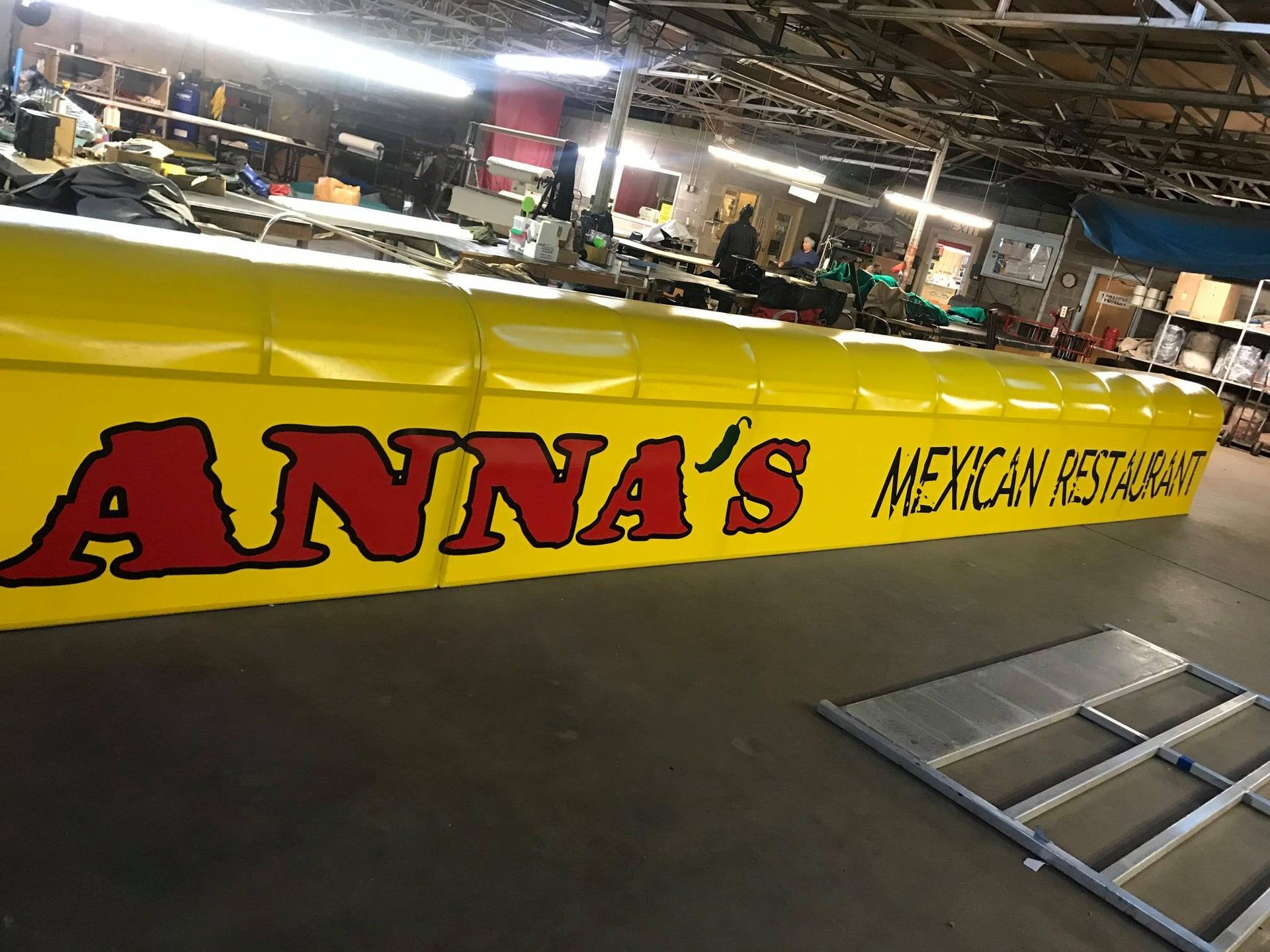 Yellow Anna's Mexican Restaurant sign with red lettering in a shop setting.