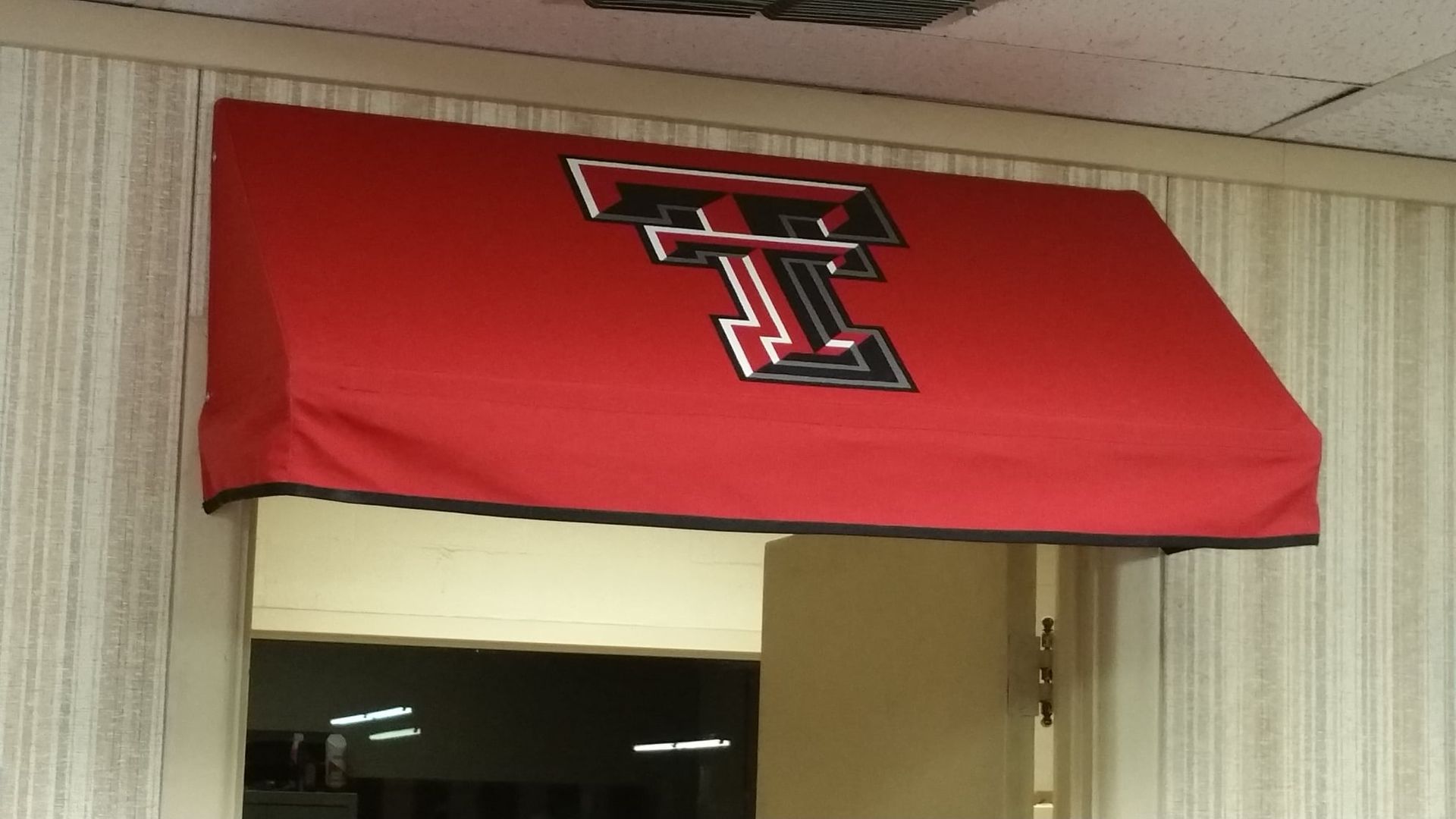 Red awning with Texas Tech logo above doorway.