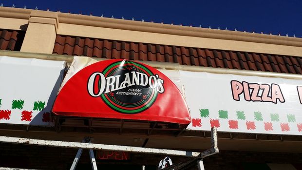 Orlando's Pizza restaurant sign with a red awning. The sign has a red and green design.