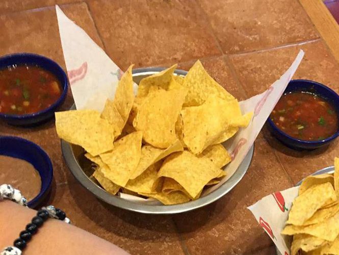 Tortilla chips in a metal basket with salsa
