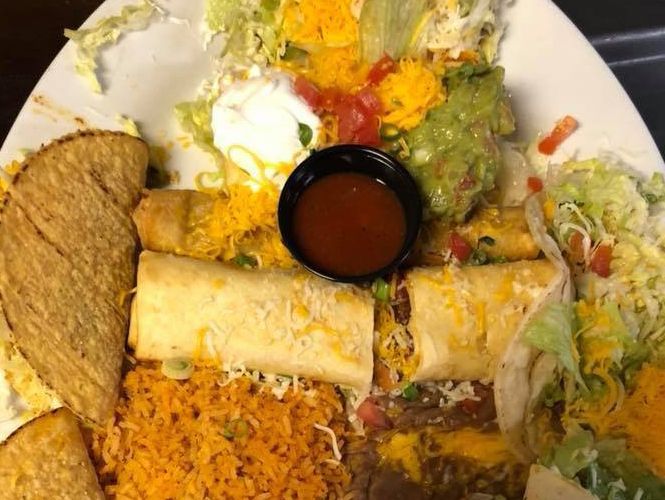 Tacos, enchiladas, rice, beans, guacamole, sour cream, cheese, and salsa