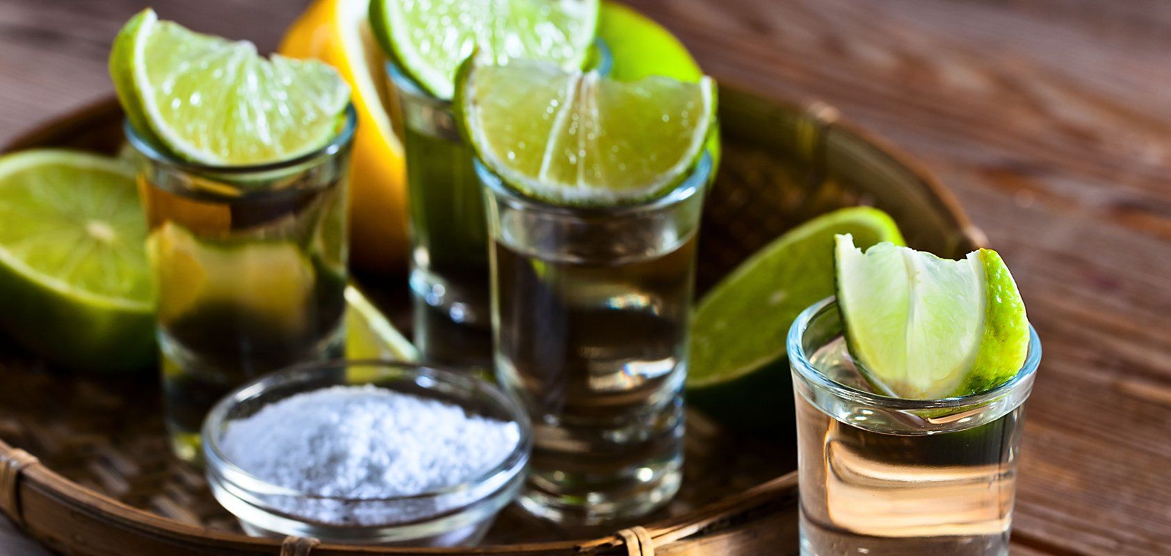 Five beer bottles lined up on a bar, with a fire pit in the background