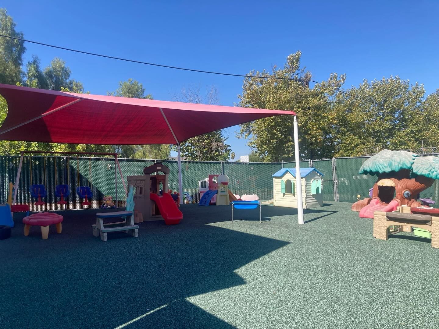 Childcare room with colorful decorations, toys, a rainbow, and a white door.