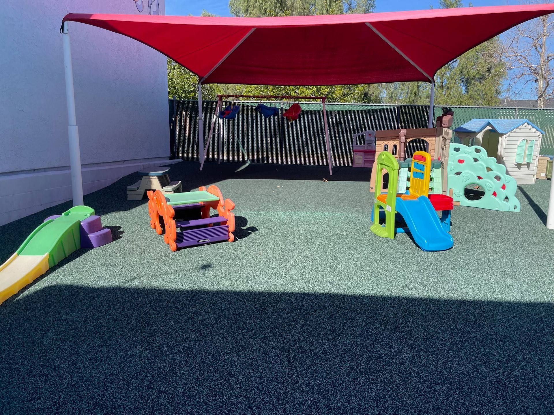 Childcare room with colorful decorations, toys, and a rainbow display.