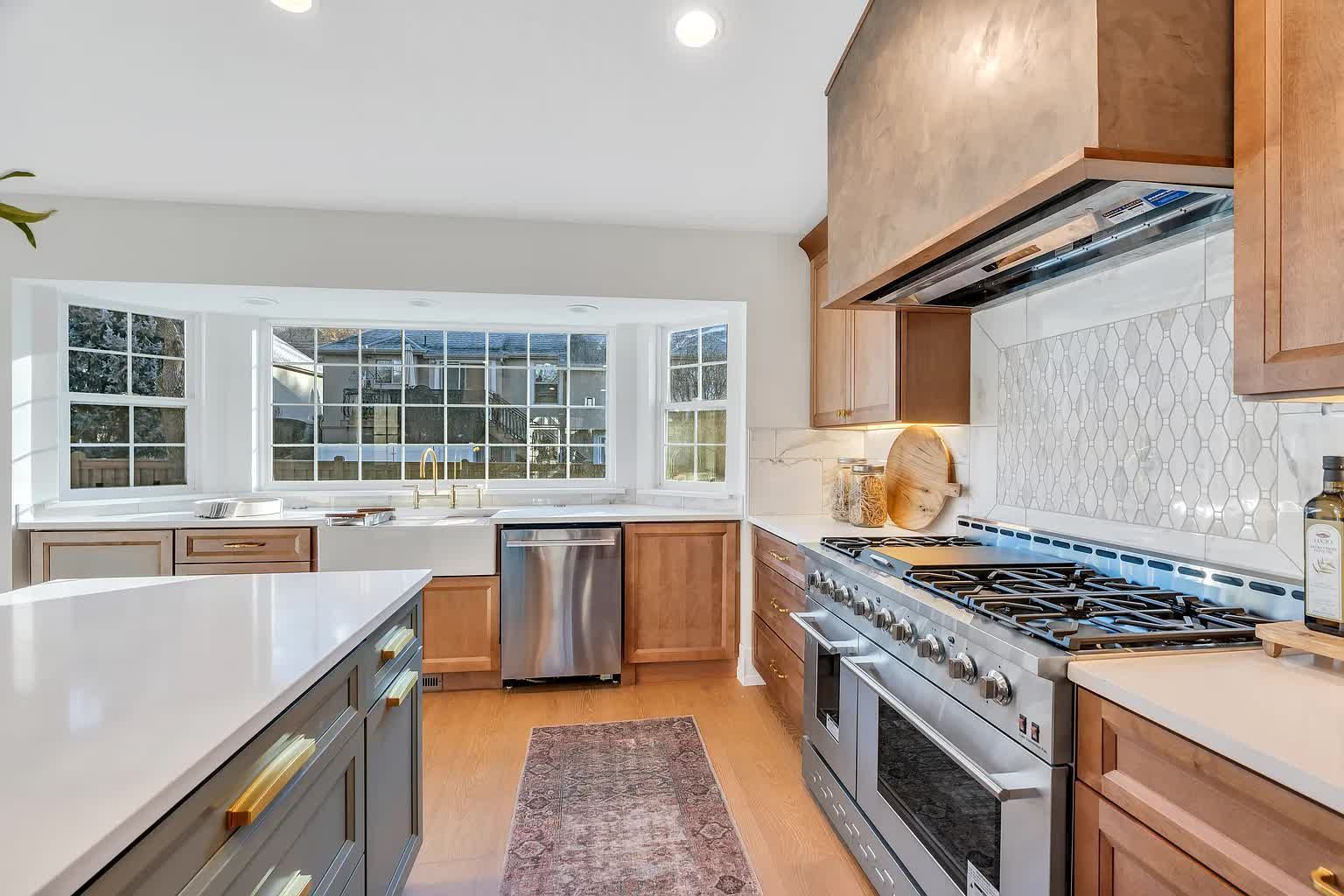 Modern kitchen with a large island, stainless steel appliances, and bay windows.