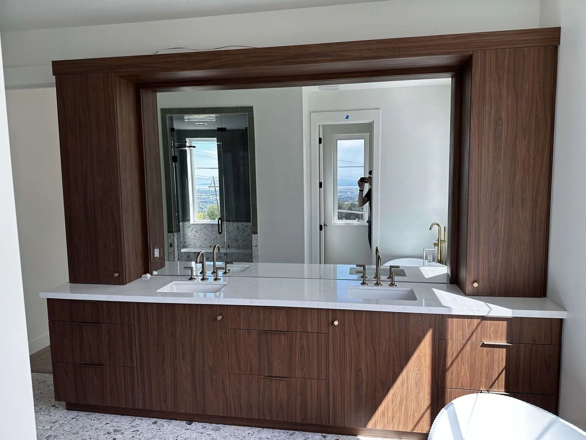 Bathroom with a long wood vanity, large mirror, and two sinks.