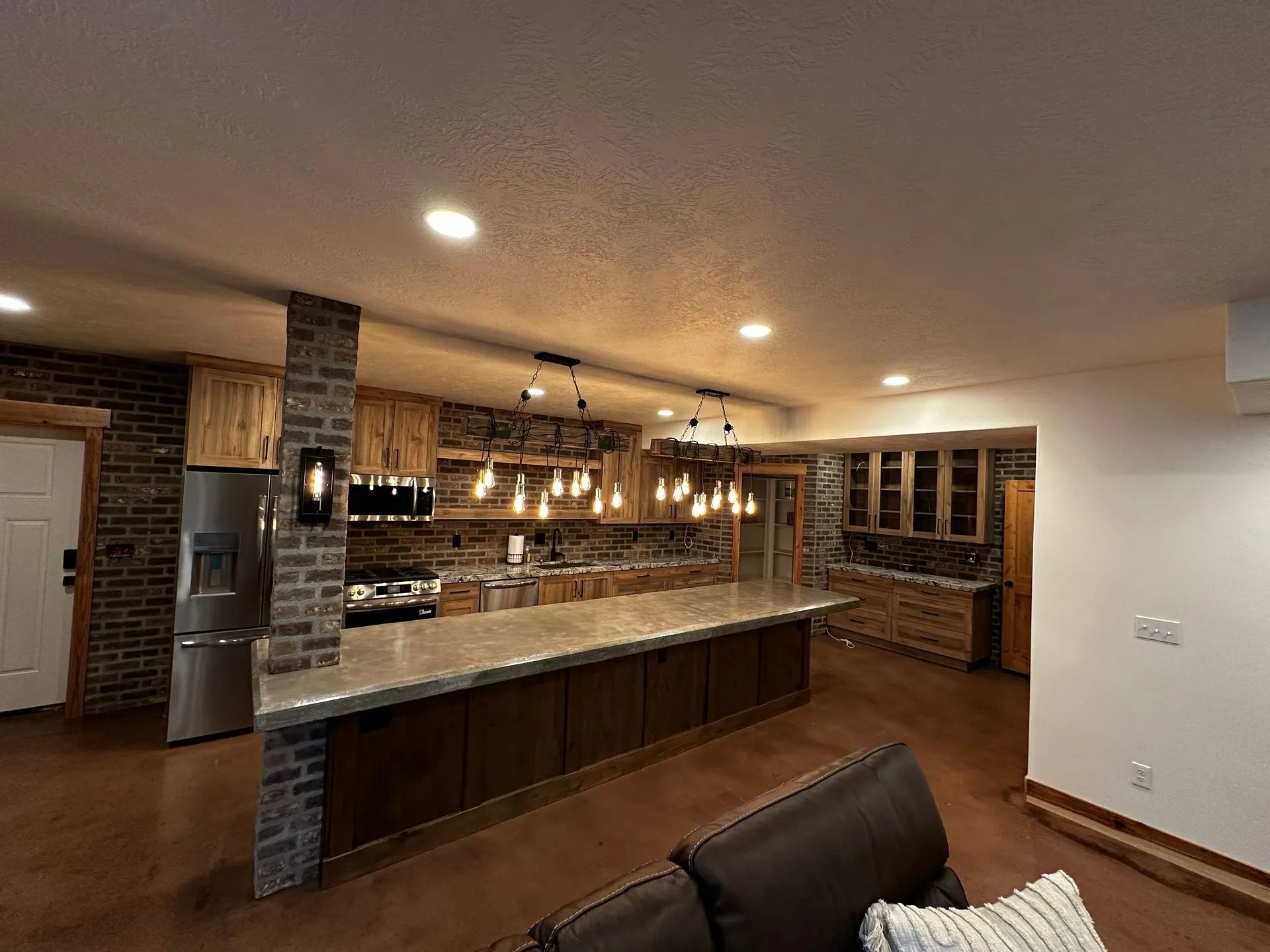 Modern kitchen with wood cabinets, brick accents, and a large island.