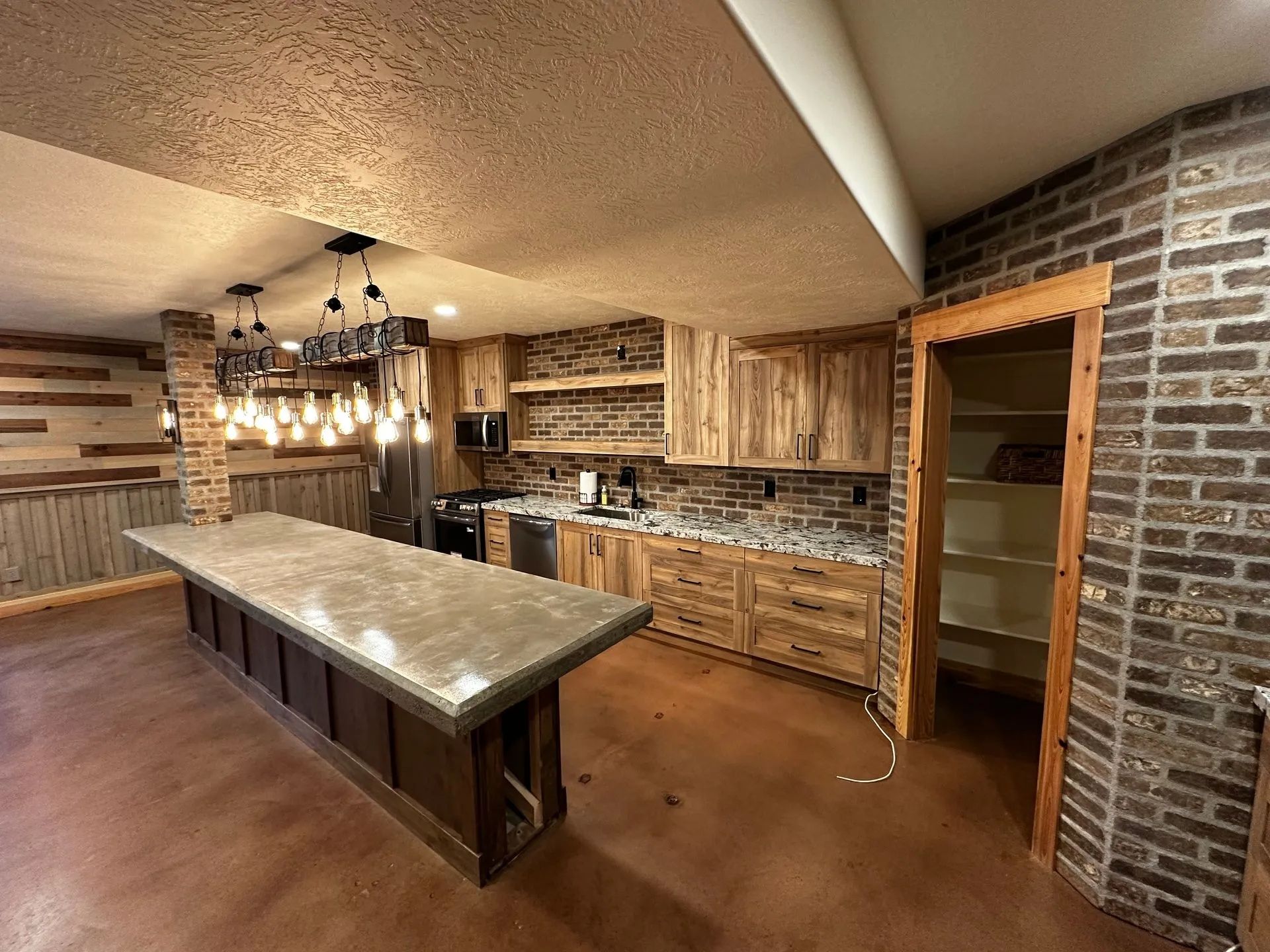 Rustic kitchen with wood cabinetry, brick accents, and a large island.