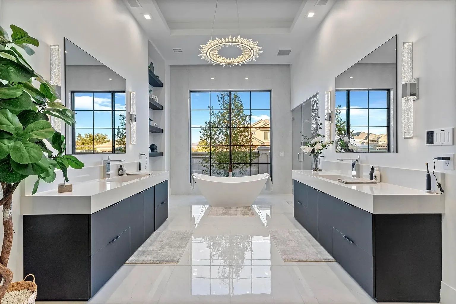 Modern bathroom with dual sinks, a bathtub, and a large window with an outdoor view.