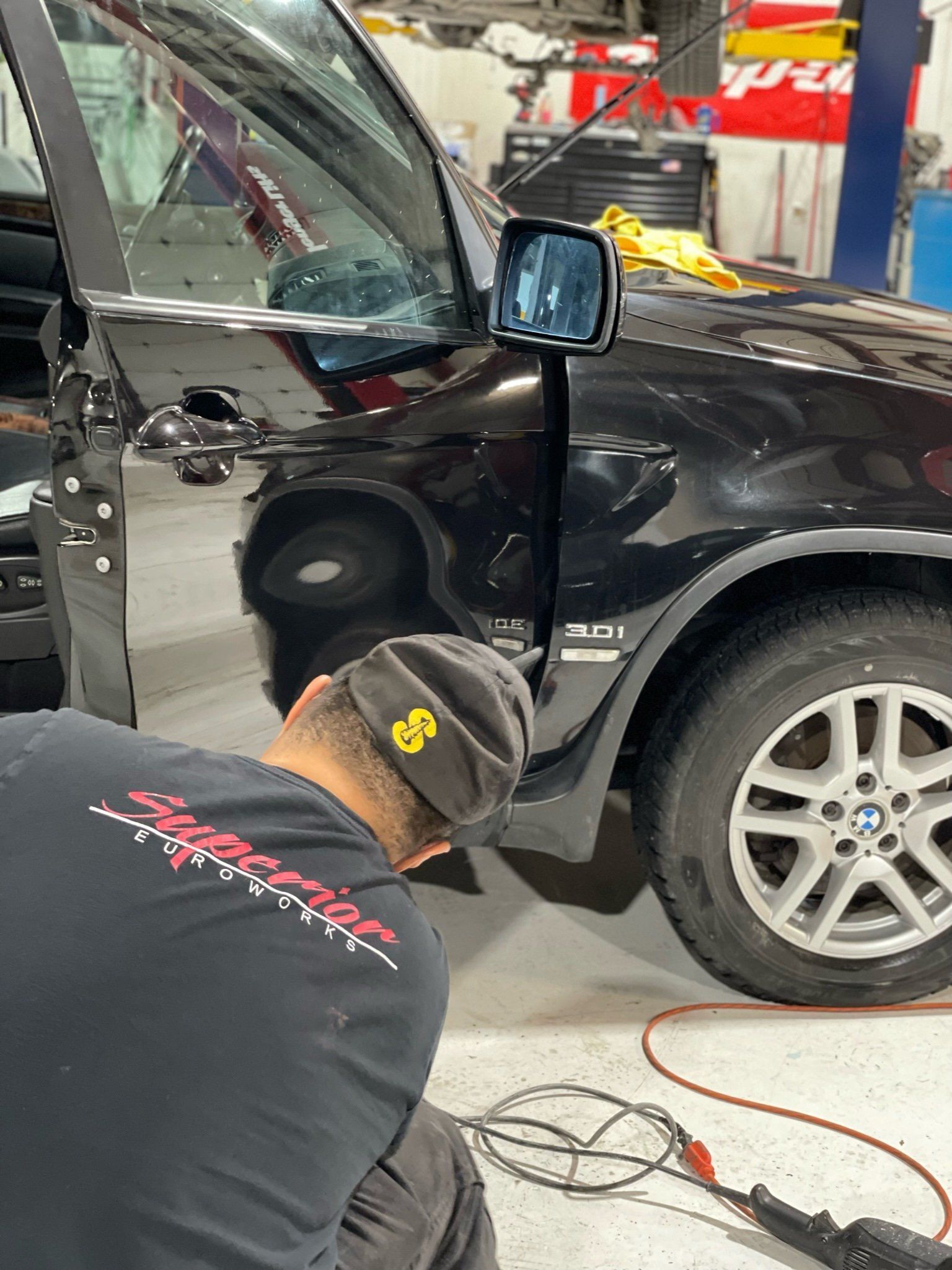 a man is working on a black car in a garage