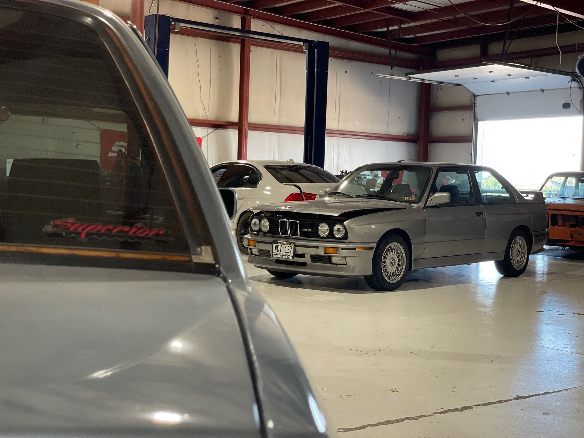 a bmw is parked in a garage with other cars