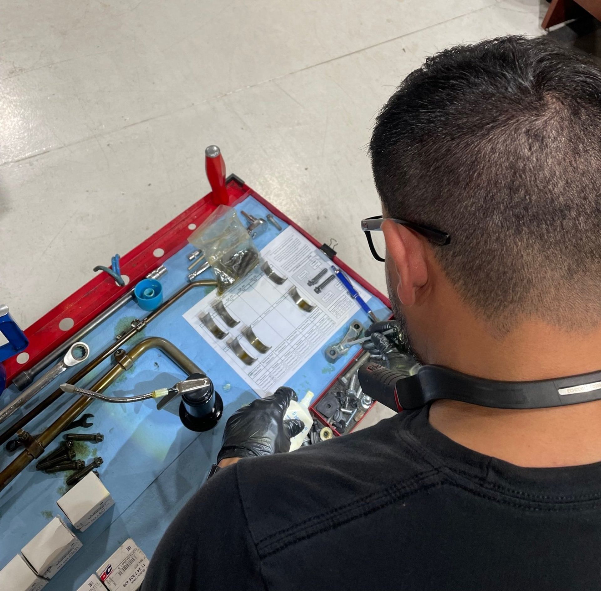 a man wearing glasses is working on a machine